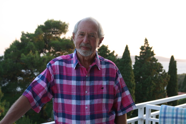 A designer committed to his craft, Bernard Higton takes a rare break, relaxing on the balcony of a holiday apartment. In this colour photograph he wears a red, white and blue check shirt.