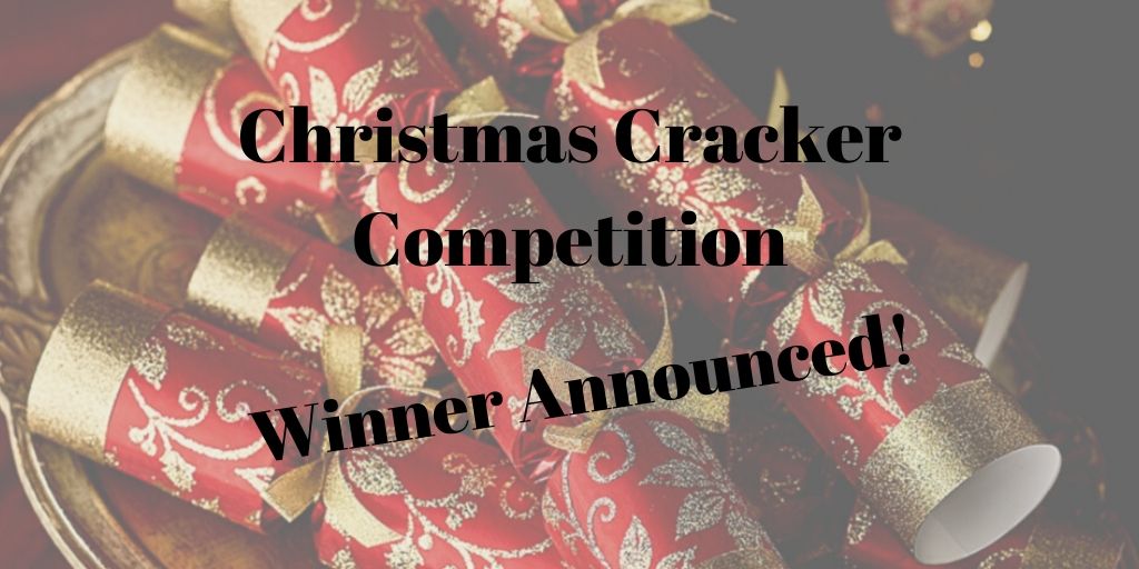 Photograph of red and gold crackers in the background, overlaid with black text announcing the winner of the Christmas Cracker Competition.