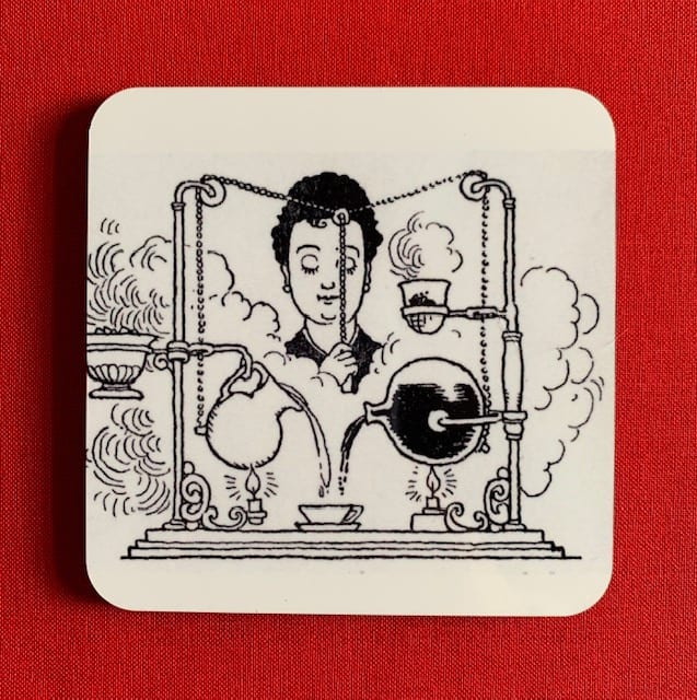 Photograph of a coaster, illustrated with the Super-De-Luxe Coffee Maker black and white line drawing and set against a red background.