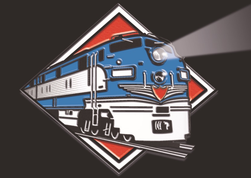 In this colour artwork of a railroad logo designed by Ian Logan, a blue diesel-electric locomotive emerges from a red frame with a white border, light beaming from its headlamp.