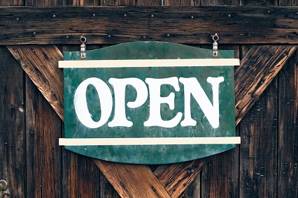 Colour photograph of an ‘Open’ sign. If you have time to read, we can send you a book.